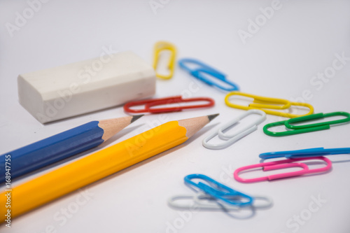 Pencil placed on a white background With an eraser placed next to it and many colors of clips