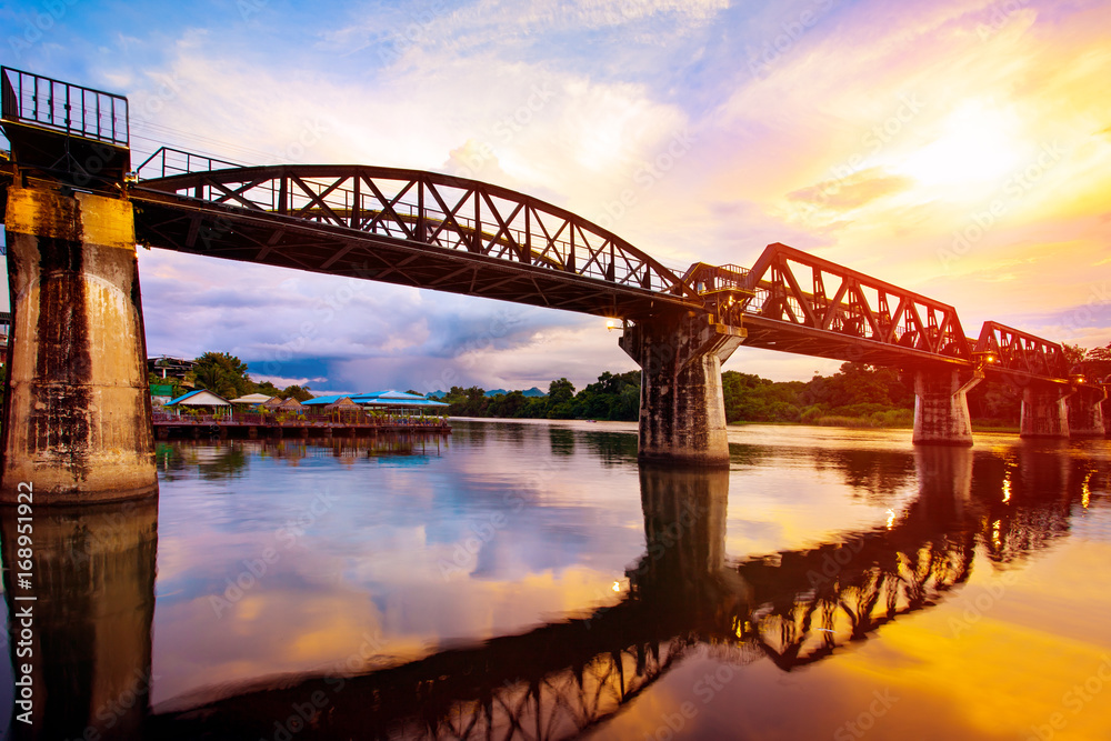 Fototapeta premium colorful twilight time of river khaw bridge in kanchanaburi most popular world war II history traveling destination in western of thailand