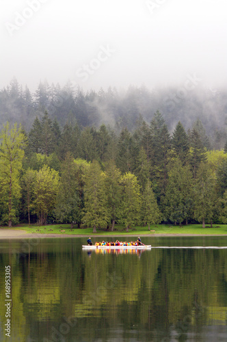 Fototapeta Naklejka Na Ścianę i Meble -  Dragon boat on calm lake with green forest