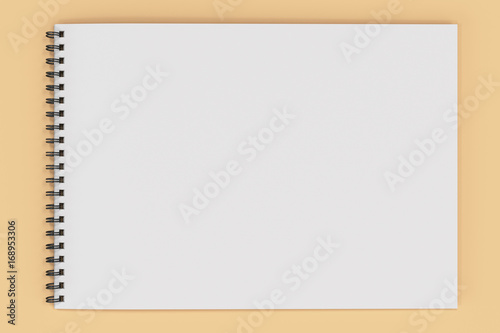 Blank white notebook with black spiral bound on orange background