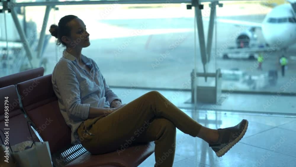 Young, pretty woman waiting for plane sitting in lobby at airport
Young, pretty woman waiting for plane sitting in lobby at airport