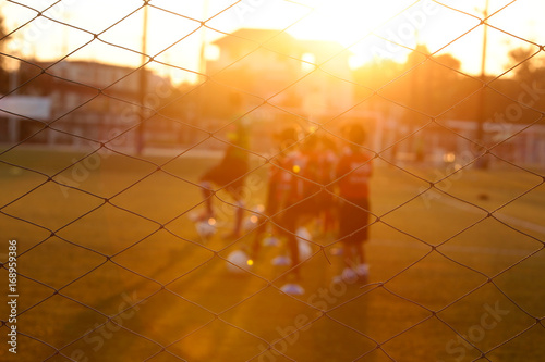 Blurred photo of youth training football in the football practice field. Sport concept.