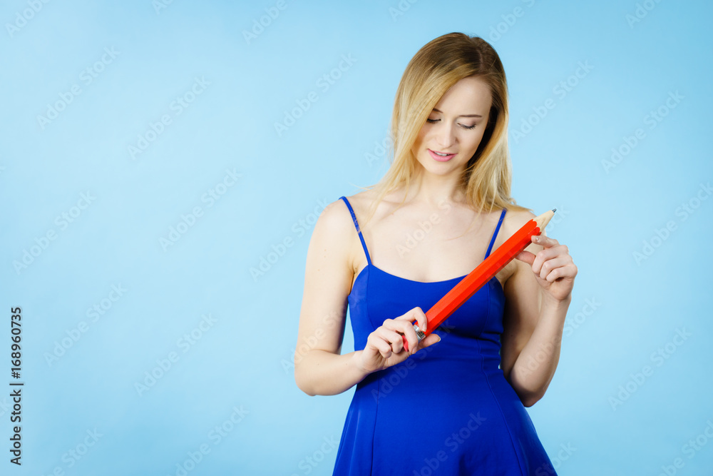 Woman confused thinking, big pencil in hand Woman confused thinking, big pencil in hand