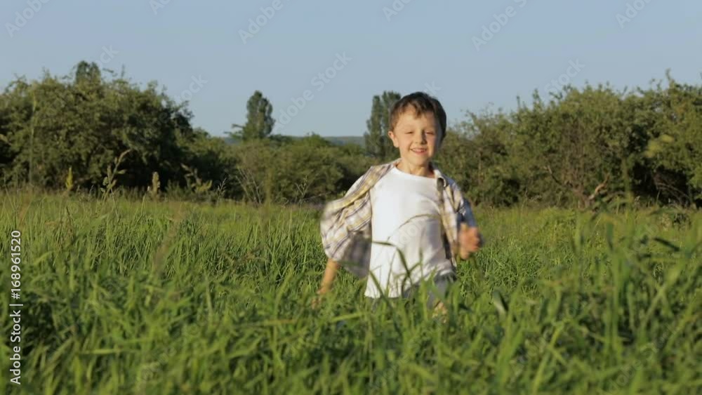 Little boy playing on the field at the day time. Child having fun outdoors. He running on the lawn. Little boy playing on the field at the day time. Child having fun outdoors. He running on the lawn.
