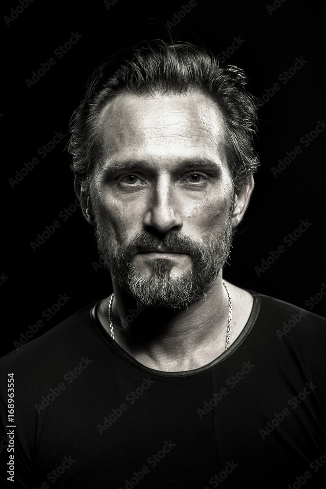Monochrome portrait of strong mature beardy man. Male with severe look on his face. Monochrome portrait of strong mature beardy man. Male with severe look on his face.