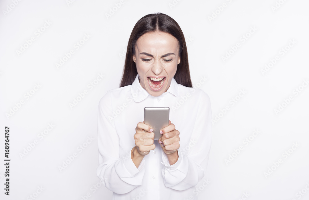 Portrait of young business woman she is screaming in phone isolated on white background. Portrait of young business woman she is screaming in phone isolated on white background.