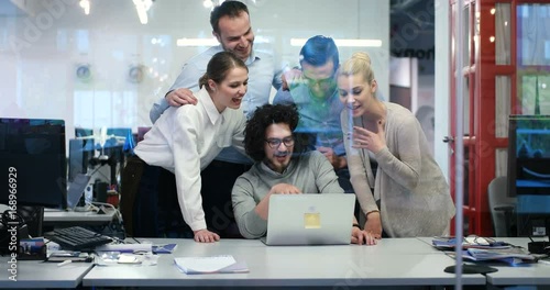 business peope discussing new ideas in fron of computer in cool statup office photo