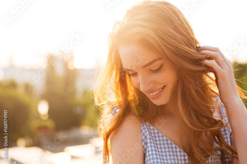 Quadro su tela Close up portrait of a redhead girl playing with hair