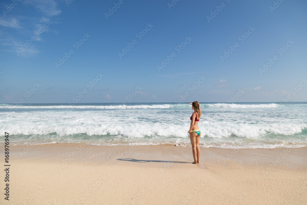 Cute attractive girl in bikini enjoying the life on the tropical beach. Summer concept.