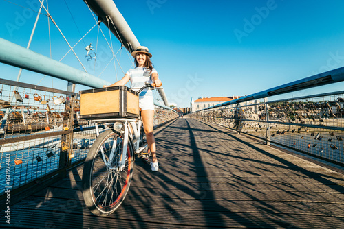 pretty woman riding bicycle on the bridge photo