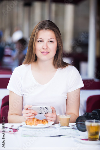 Tourist using mobile phone in cafe