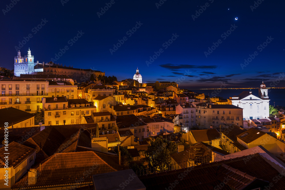 View of the Alfama neighborhood from the Portas do Sol viewpoint at night in Lisbon, Portugal; Concept for travel in Portugal View of the Alfama neighborhood from the Portas do Sol viewpoint at night in Lisbon, Portugal; Concept for travel in Portugal