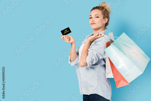Satisfied woman with shopping bags and VIP card in hand