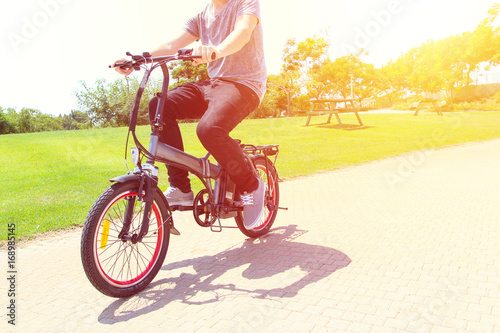 A man riding  on electric bicycle in a park photo