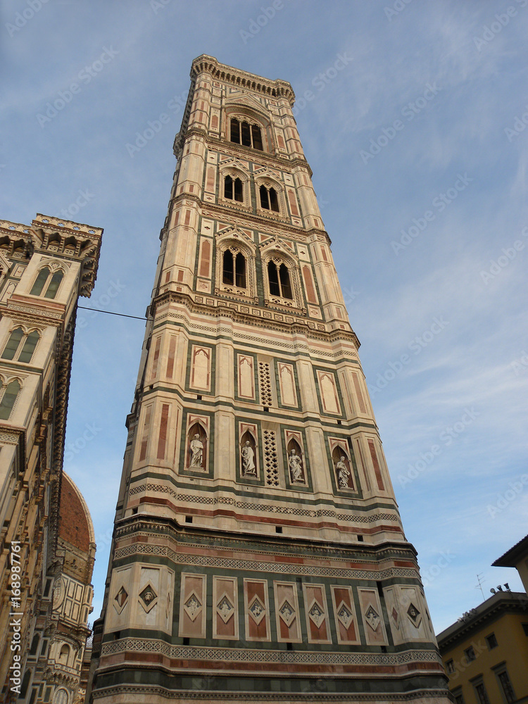 FLORENCE, ITALY - MAY 30, 2017: Giotto’s Campanile, adjacent to the Basilica of Santa Maria del Fiore and the Baptistry of St. John, and one of the showpieces of Florentine Gothic. FLORENCE, ITALY - MAY 30, 2017: Giotto’s Campanile, adjacent to the Basilica of Santa Maria del Fiore and the Baptistry of St. John, and one of the showpieces of Florentine Gothic.