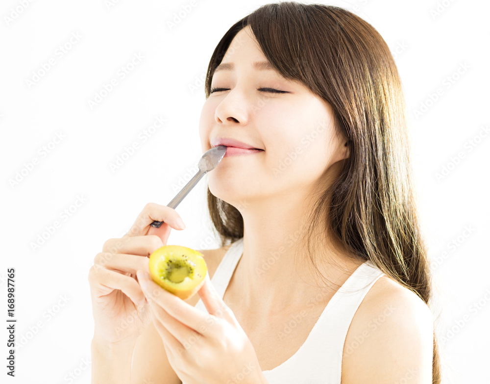 Happy young woman eating kiwi fruit Happy young woman eating kiwi fruit