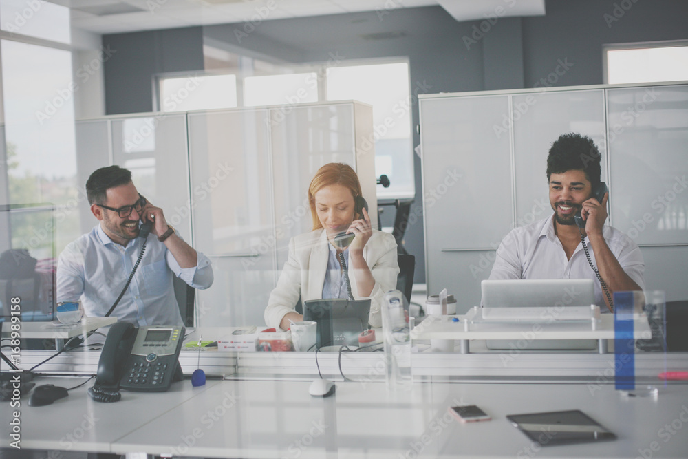 Fototapeta premium People in operations center talking on Landline phone. Operators in the office.