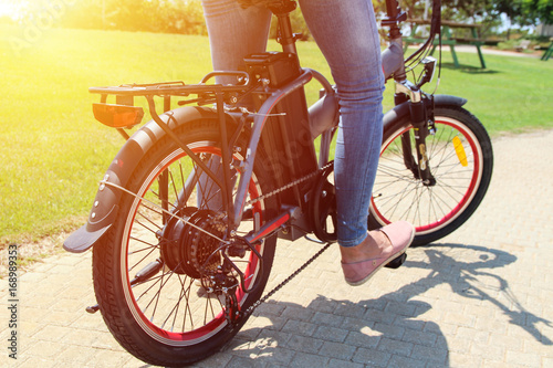 A woman on electric bicycle in a park