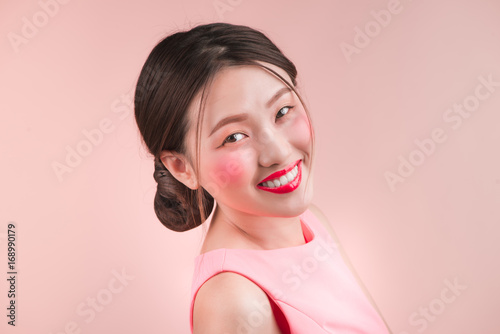 Pretty young charming smiling woman close-up on a pink background