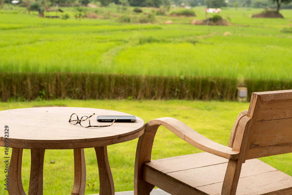 Glasses and mobile phone on chair with rice field background. Glasses and mobile phone on chair with rice field background.