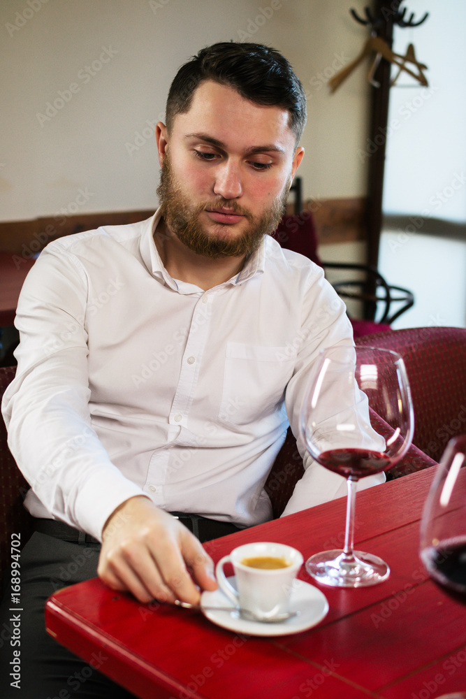Young attractive man sitting in cafe and taking a cup of coffee Young attractive man sitting in cafe and taking a cup of coffee