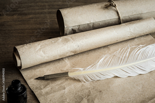 Old quill pen on the old paper. Letter writing. Historical atmosphere.