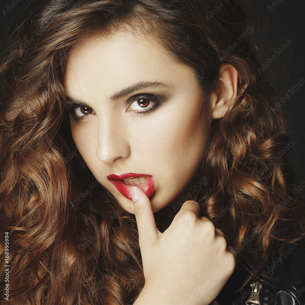 Fototapeta premium Beautiful young woman posing in black leather jacket over grey background. Fashion concept.