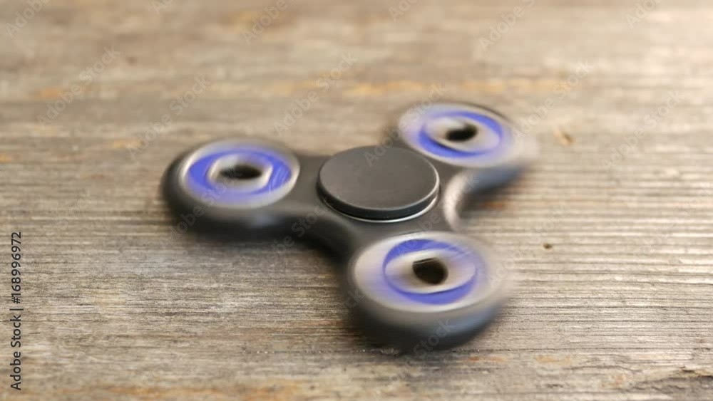 Popular fidget spinner spinning on rustic table