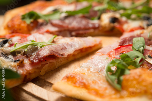 Pizza with champignons and arugula on a wooden plate 