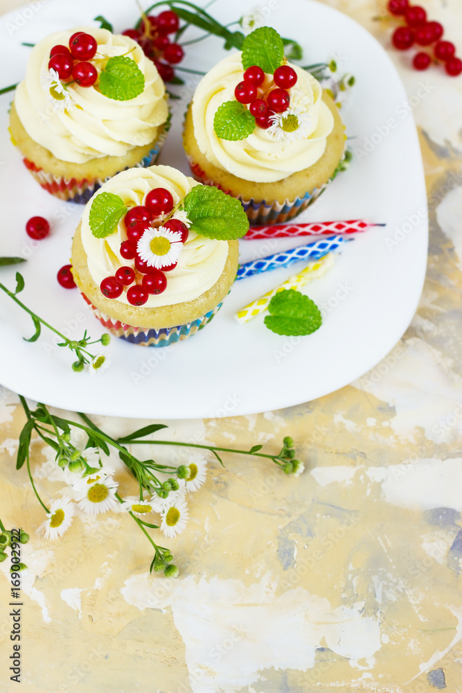 Gentle cupcake with cream and berries аnd a candle a light background