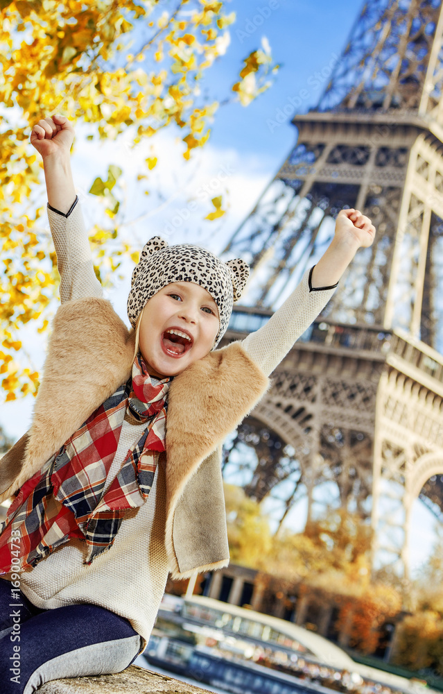happy elegant child on embankment in Paris, France rejoicing