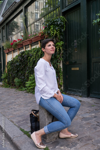 Jolie jeune femme assise dans une rue de Montmartre à Paris