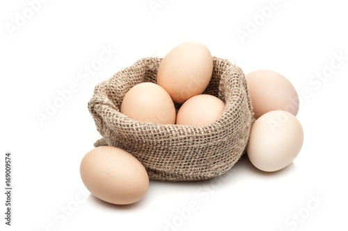 chicken eggs in burlap sack isolated on white background