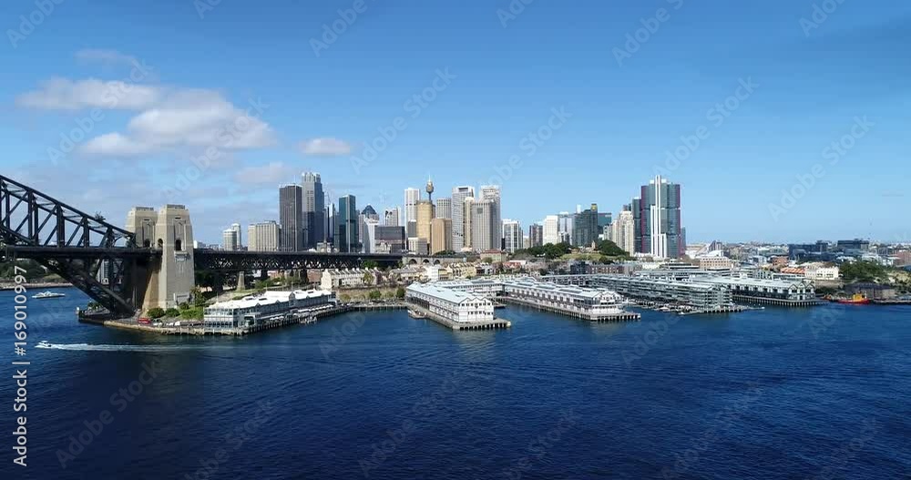 Approaching The Rocks and distant Sydney city CBD waterfront from mid-air on a sunny day. Approaching The Rocks and distant Sydney city CBD waterfront from mid-air on a sunny day.