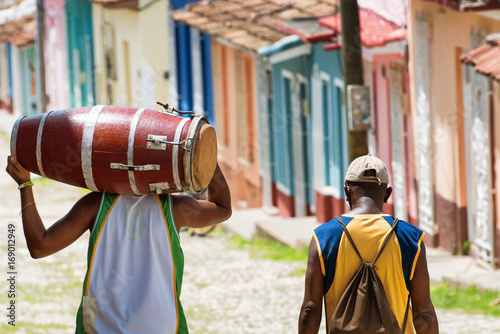 Canvas Print Salsa musician carrying a conga while walking in the streets of Trinidad Cuba wi