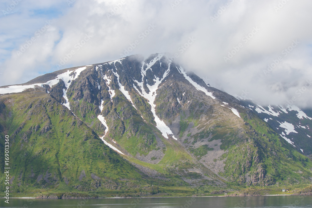 Mountain in clouds on Soroya island in Finnmark county in northern Norway.