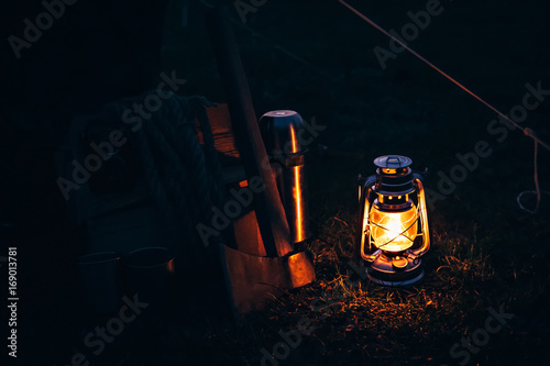 Flashlight vintage gas lantern lighting on the grass. Travel cam photo