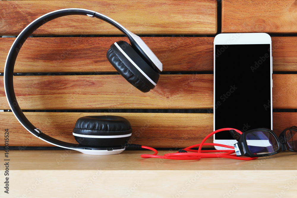 Headphones  and smartphone on wood floor background ,Concept listen to music