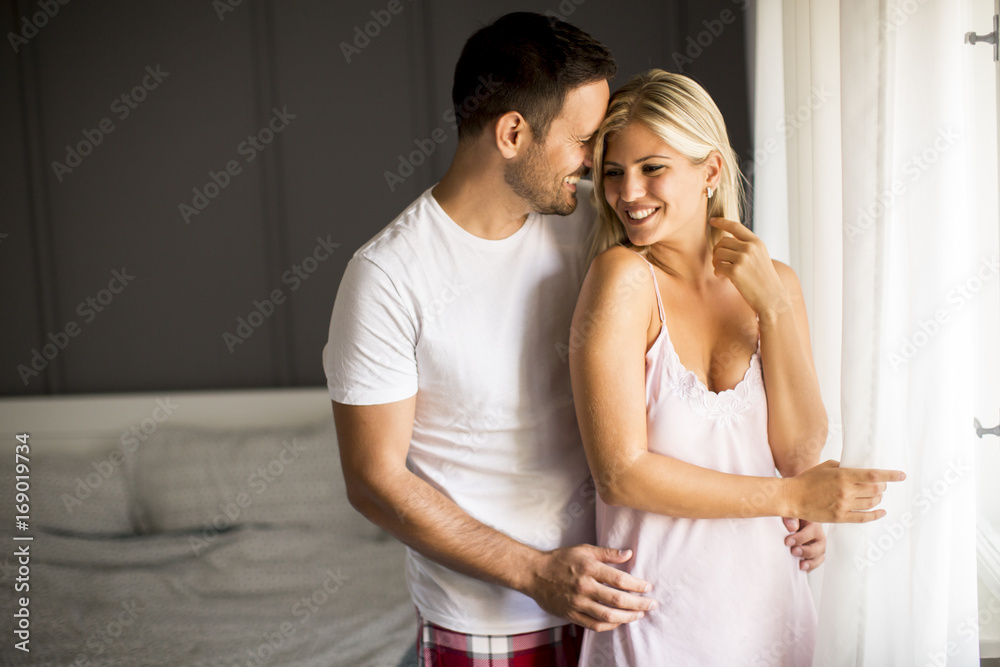 Naklejka premium Lovely young couple standing by the window at morning