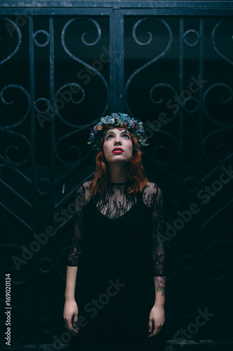 Woman wearing a flower crown and goth clothing