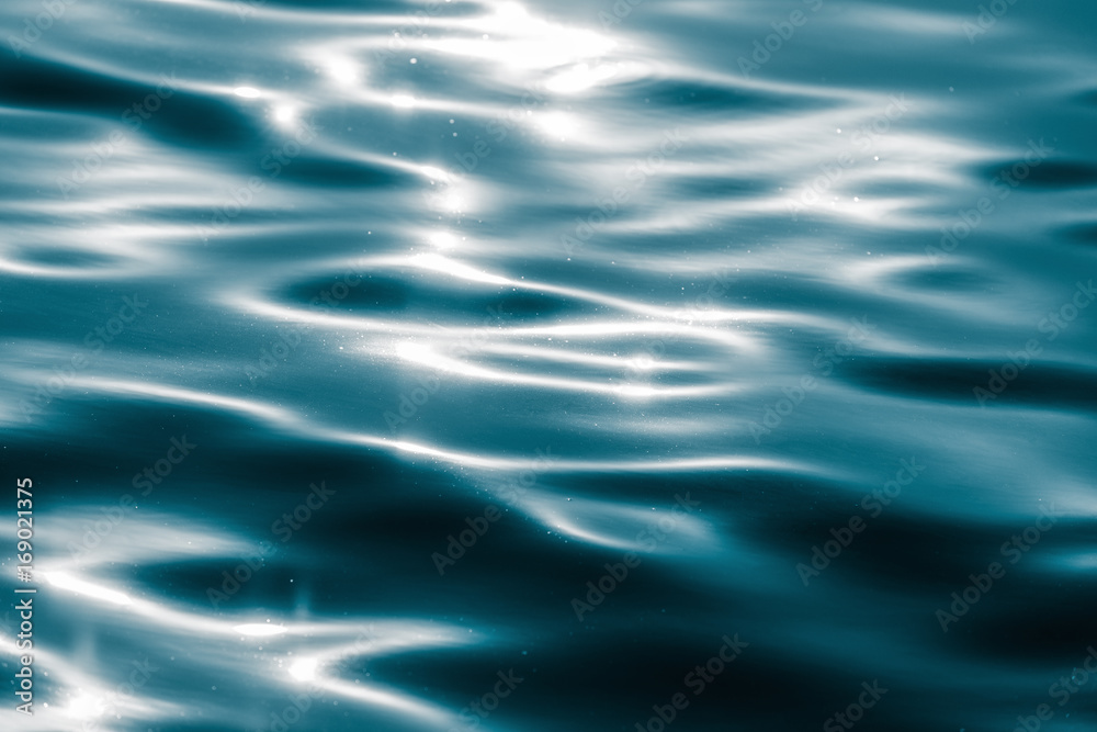 Naklejka premium Water surface with moving wave of blue water reflecting light