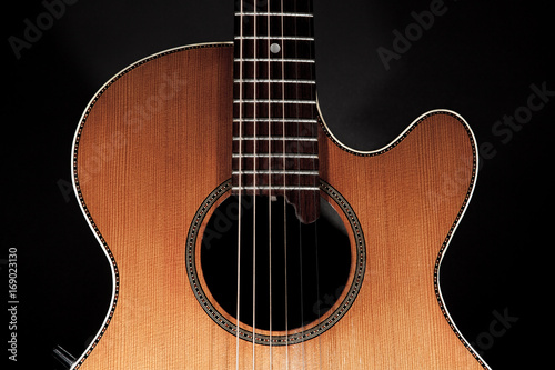 Roundback acoustic guitar with rosette purfling and extended fingerboard in close up.