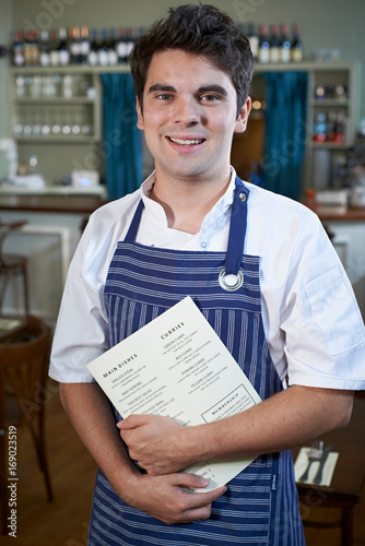 Φωτογραφία Portrait Of Chef Standing In Restaurant Holding Menu