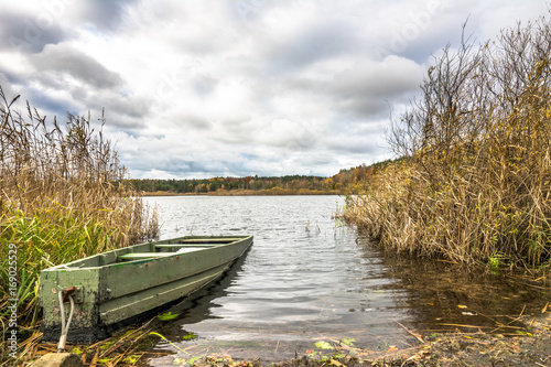 Fishing boat over lake  scenic landscape  autumn scenery with cloudy weather