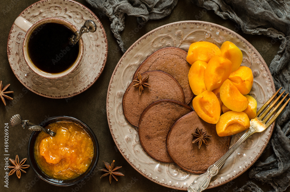 Fototapeta premium Chocolate pancakes with apricot jam and coffee
