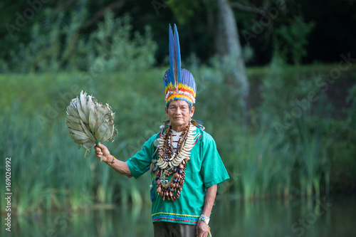 Concentrated ethnic priest on lakeside photo