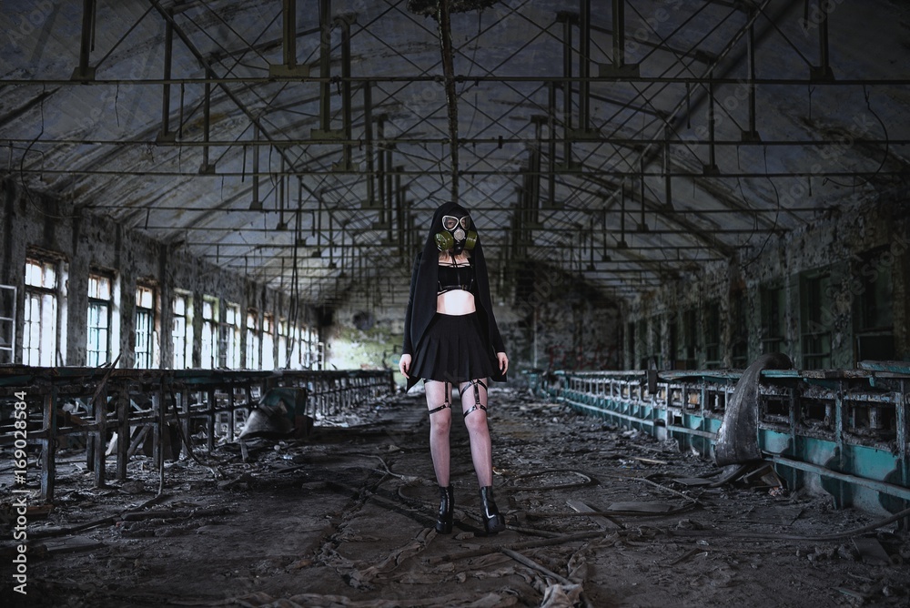 Beautiful, young girl post apocalypse girl stand in abandoned factory with gas mask Beautiful, young girl post apocalypse girl stand in abandoned factory with gas mask