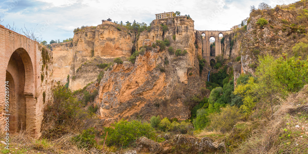 Fototapeta premium Panorama of Ronda, mountains and Puente Nuevo or New Bridge, over the Tajo Gorge, Andalusia, Spain