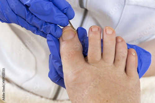 фотографія cuticles being pushed back during pedicure and footcare process, important for d