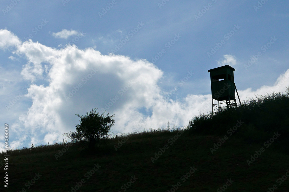 Silhouette eines Hochsitzes gegen blauen Himmel